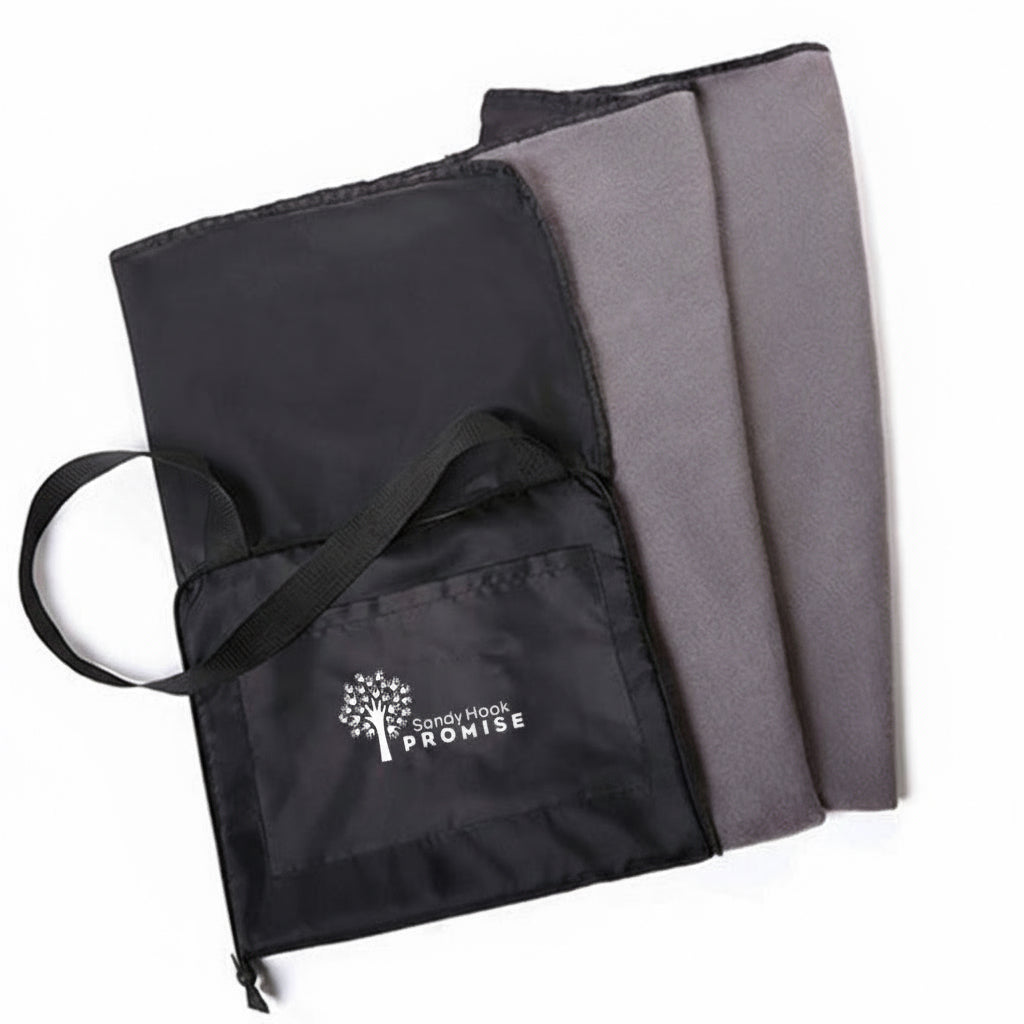 Black bag with 'Sandy Hook Promise' logo held by a person outdoors.
