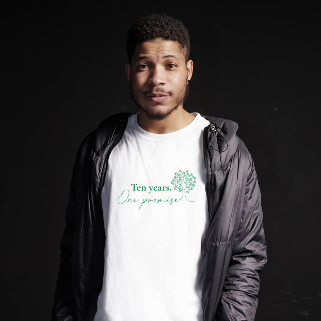 Man wearing Sandy Hook Promise's white Classic Remembrance T-Shirt. Artwork text: Ten years. One Promise
